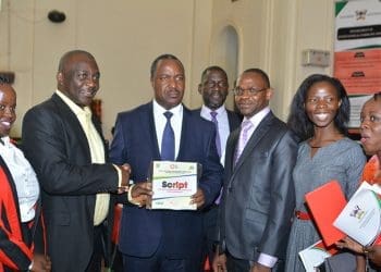 Prof. Emmanuel Dandaura of Nigeria’s Nasarawa State University handing over a curriculum book to Uganda’s Minister for Science, Technology and Innovation, Elioda Tumwesigye, during the Makerere University Annual Media Convention on April 25 2019.