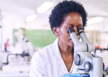 Science communication award story image: Female African scientists in a laboratory looking through a microscope