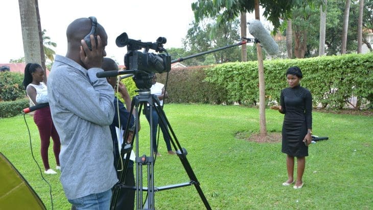Woman being interviewed by journalists at Makerere